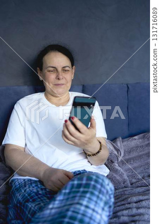 a senior woman chatting on the phone in bed 131716089