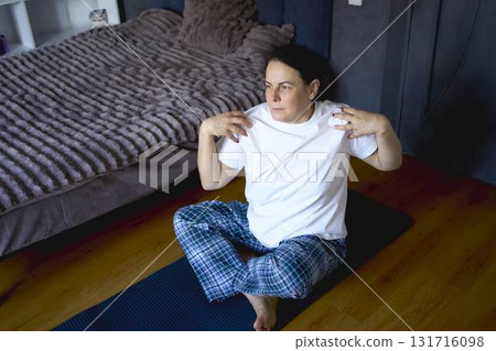 a senior woman performs somatic exercises, yoga at home a senior woman performs somatic exercises, yoga at home 131716098