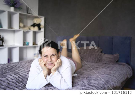 a senior woman in underwear stretching, resting, enjoying life on bed at home a senior woman in underwear stretching, resting, enjoying life on bed at home 131716113