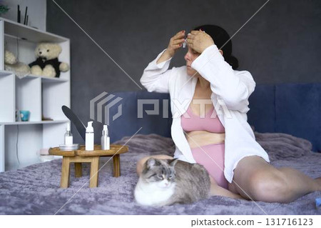 a senior woman in underwear on the bed performs routine self-care with face and body cosmetics a senior woman in underwear on the bed performs routine self-care with face and body cosmetics 131716123