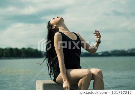 An athlete with a toned figure practices yoga in the fresh air 131717212