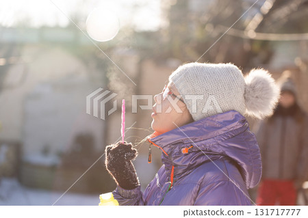 Outdoor winter fun blowing soap bubbles 131717777