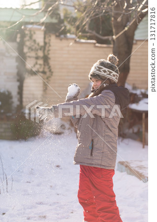Boy playing snowball fight outdoors on sunny winter day Boy playing snowball fight outdoors on sunny winter day 131717816