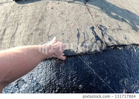 Roofing from roofing felts and resin. Sealing roofing material on roof. Roofing from roofing felts and resin. Sealing roofing material on roof. 131717884