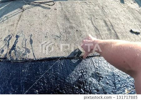 Roofing from roofing felts and resin. Sealing roofing material on roof. Roofing from roofing felts and resin. Sealing roofing material on roof. 131717885