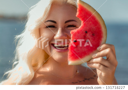 Watermelon Woman Summer Beach: Joyful blonde woman holds a bitten watermelon slice outdoors, sunny day. Watermelon Woman Summer Beach: Joyful blonde woman holds a bitten watermelon slice outdoors, sunny day. 131718227