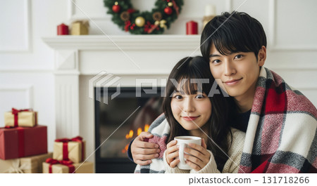 情侶們在壁爐前的毯子下依偎在一起 情侶們在壁爐前的毯子下依偎在一起 131718266