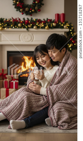 情侶們在壁爐前的毯子下依偎在一起 131718267