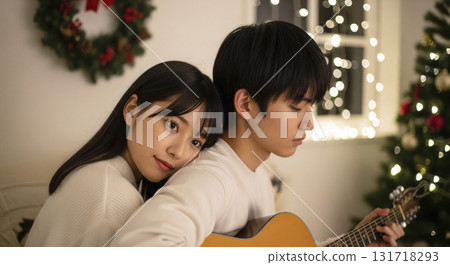 Lovers cuddling in a warmly lit room playing guitar 131718293