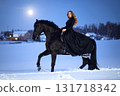 Snowy moonlit night, black horse and woman in black dress_01 131718342