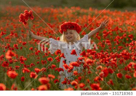 A young girl is standing in a field of red poppies, holding a bouquet of flowers. She is smiling and she is enjoying the beautiful scenery. Concept of joy and happiness A young girl is standing in a field of red poppies, holding a bouquet of flowers. She is smiling and she is enjoying the beautiful scenery. Concept of joy and happiness 131718363