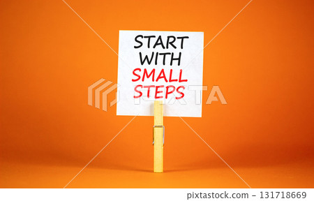 Start with small steps symbol. Concept words phrase Start with small steps on beautiful white paper on clothespin. Beautiful orange background. Business Start with small steps concept. Copy space. 131718669
