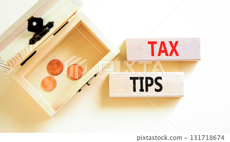 Tax tips symbol. Concept word Tax tips on beautiful wooden blocks. Beautiful white paper background. Beautiful wooden chest with coins. Business tax tips concept. Copy space. Tax tips symbol. Concept word Tax tips on beautiful wooden blocks. Beautiful white paper background. Beautiful wooden chest with coins. Business tax tips concept. Copy space. 131718674
