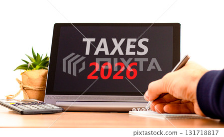 Taxes 2026 new year symbol. Concept words Taxes 2026 on beautiful black tablet screen. Beautiful white background. Businessman's hand. Business and taxes 2026 new year concept. Copy space. 131718817