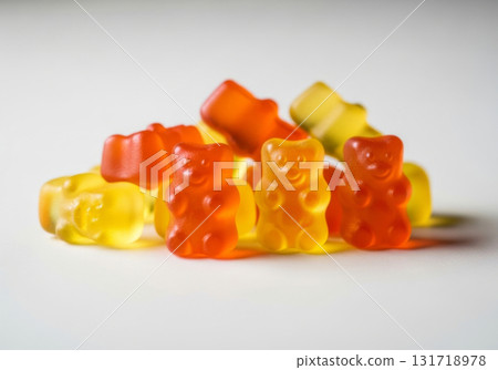 Close-up texture of orange and yellow multivitamin bears gummies in the form of bears on white background 131718978
