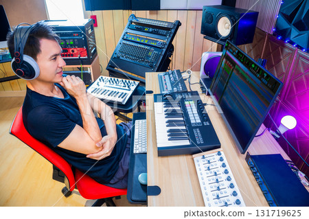asian male music producer, sound engineer, composer, musician. artist enjoy listening his song in home studio. 131719625