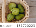 Several fresh green chayote fruits in a wicker basket top view. Organic tropical vegetable harvest. Healthy vegan food and sustainable farming concept 131720223