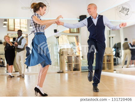 Man and woman performing jazz dance in dancing room Man and woman performing jazz dance in dancing room 131720406