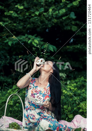 A young girl with black hair at a picnic in the forest A young girl with black hair at a picnic in the forest 131720464