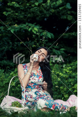 A young girl with black hair at a picnic in the forest 131720465
