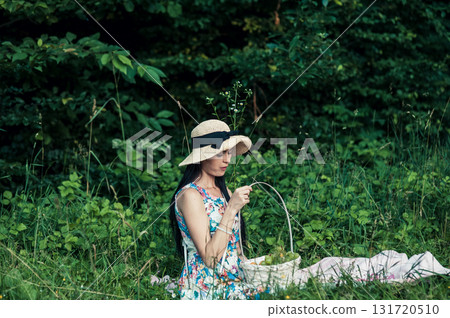 A beautiful girl at a picnic in the forest. A delicate girl at a picnic with a basket of fruit. A beautiful girl relaxes at a picnic against a backdrop of green bushes and trees. A beautiful girl at a picnic in the forest. A delicate girl at a picnic with a basket of fruit. A beautiful girl relaxes at a picnic against a backdrop of green bushes and trees. 131720510