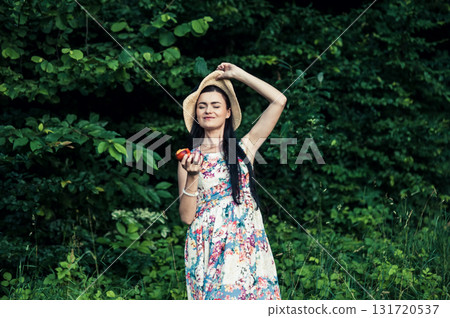 A cute girl with two red apples in the forest 131720537
