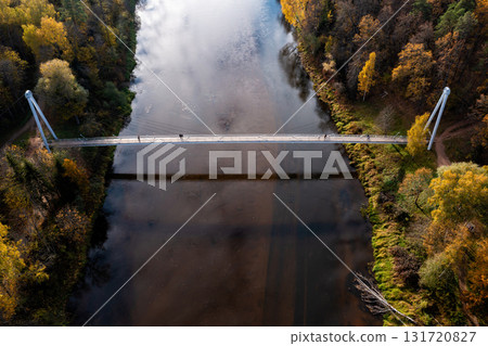 pedestrian bridge over the river Gauja near the devil cliff on a autumn day, Krimulda, Latvia 131720827