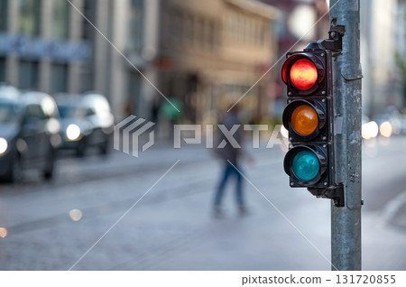 view of city traffic with traffic lights, in the foreground a traffic light with a red light view of city traffic with traffic lights, in the foreground a traffic light with a red light 131720855