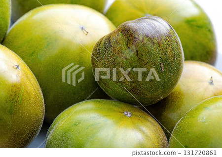 fresh and delicious tomatoes of green-black colored sort on a wooden table, closeup 131720861