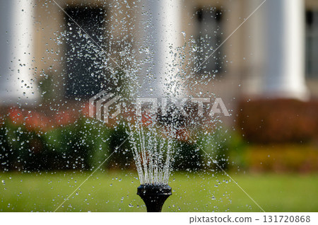 fountain splash close-up on a defocused background of an old manor, selective focus 131720868