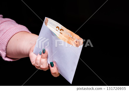 hand holding euro banknotes in the envelope isolated on black background, corruption, bribe hand holding euro banknotes in the envelope isolated on black background, corruption, bribe 131720935