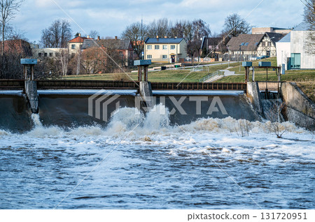 Spring flood water flows over the locks on the Berze river in Dobele, Latvia 131720951