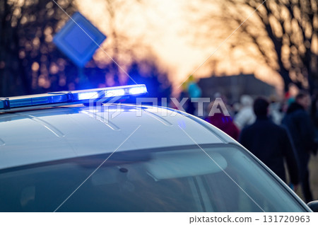 municipal police car with beacons on instead of "Stand With Ukraine" rally, evening lights 131720963