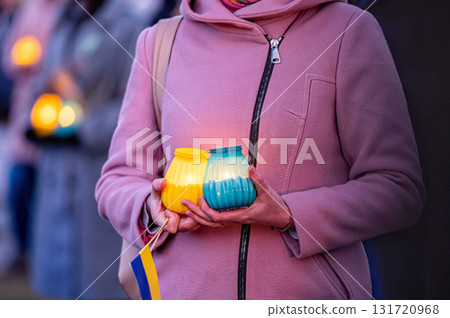 Ukrainian flags, candles and torches in the hands of protesters at the rally "Stand With Ukraine", closeup 131720968