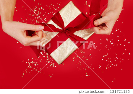 Beautifully Wrapped Gift Adorned with a Charming Red Ribbon on a Festive Background 131721125