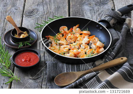 rosemary and garlic seared shrimps in a skillet rosemary and garlic seared shrimps in a skillet 131721689