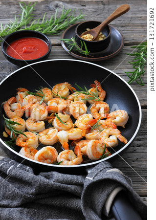 rosemary and garlic seared shrimps in a skillet 131721692