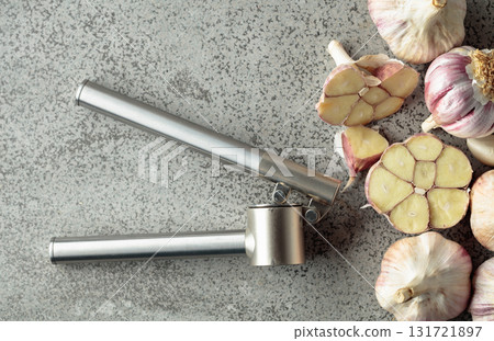 Garlic and garlic press on a kitchen table. Garlic and garlic press on a kitchen table. 131721897