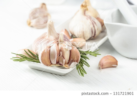 Fresh garlic bulbs with rosemary. 131721901