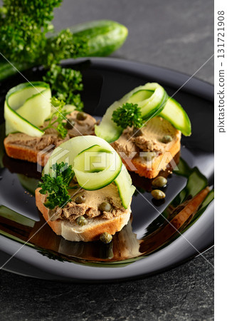 Open sandwiches with pate, fresh cucumber, capers, and parsley. Open sandwiches with pate, fresh cucumber, capers, and parsley. 131721908