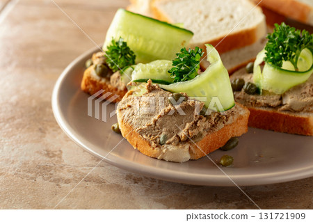 Open sandwiches with pate, cucumber, capers, and parsley. Open sandwiches with pate, cucumber, capers, and parsley. 131721909