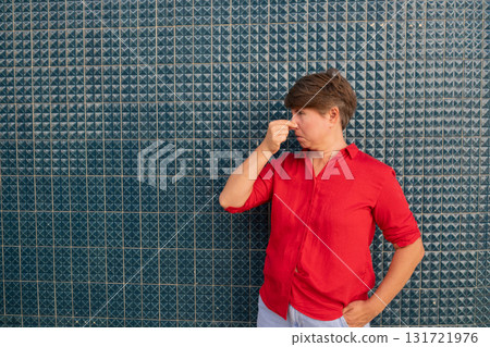 Woman covering her nose because of bad smell in front of a Portuguese tiled house Woman covering her nose because of bad smell in front of a Portuguese tiled house 131721976