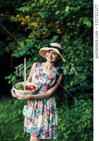 A young girl stands on green grass next to a pink picnic blanket A young girl stands on green grass next to a pink picnic blanket 131722177