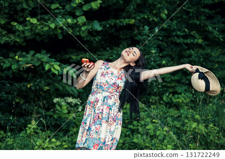 A cute woman with two red apples in the forest 131722249