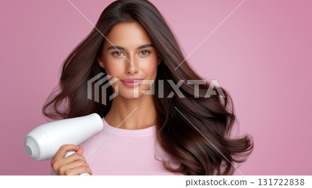 Woman looks at camera while drying her long, shiny hair with a white hair dryer. Soft pink backdrop enhances beauty and elegance. Concept of hair care, beauty industry, personal grooming. Woman looks at camera while drying her long, shiny hair with a white hair dryer. Soft pink backdrop enhances beauty and elegance. Concept of hair care, beauty industry, personal grooming. 131722838