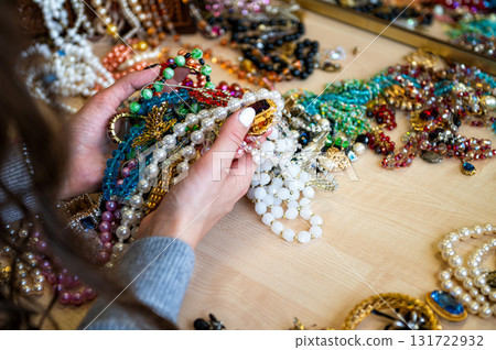 female hands holding a pile of jewelry, close-up 131722932