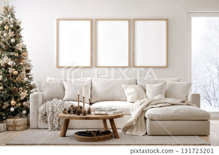 Cozy living room decorated for the holidays with a stylish sofa, festive tree, and warm natural light. Empty vertical frames set of 3 for wall art mockup. 131723201