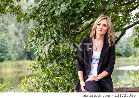 blonde woman siting on a railing wooden walkway above the pound blonde woman siting on a railing wooden walkway above the pound 131723380