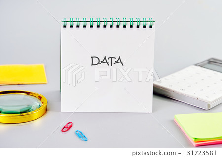 DATA word written in a notebook in a composition with a calculator, a magnifying glass, and stickers. Business strategy success concept DATA word written in a notebook in a composition with a calculator, a magnifying glass, and stickers. Business strategy success concept 131723581