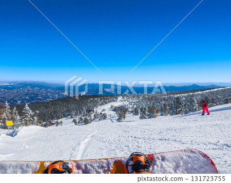 A view of the vast ski resort and mountain ranges from the perspective of a snowboarder taking a break (Shibu Pass, Gunma Prefecture) A view of the vast ski resort and mountain ranges from the perspective of a snowboarder taking a break (Shibu Pass, Gunma Prefecture) 131723755